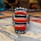 Handcrafted sterling silver ring by Bernyse Chavez featuring multiple stacked coral stones in a bold vertical arrangement with traditional Southwestern Native American detailing.