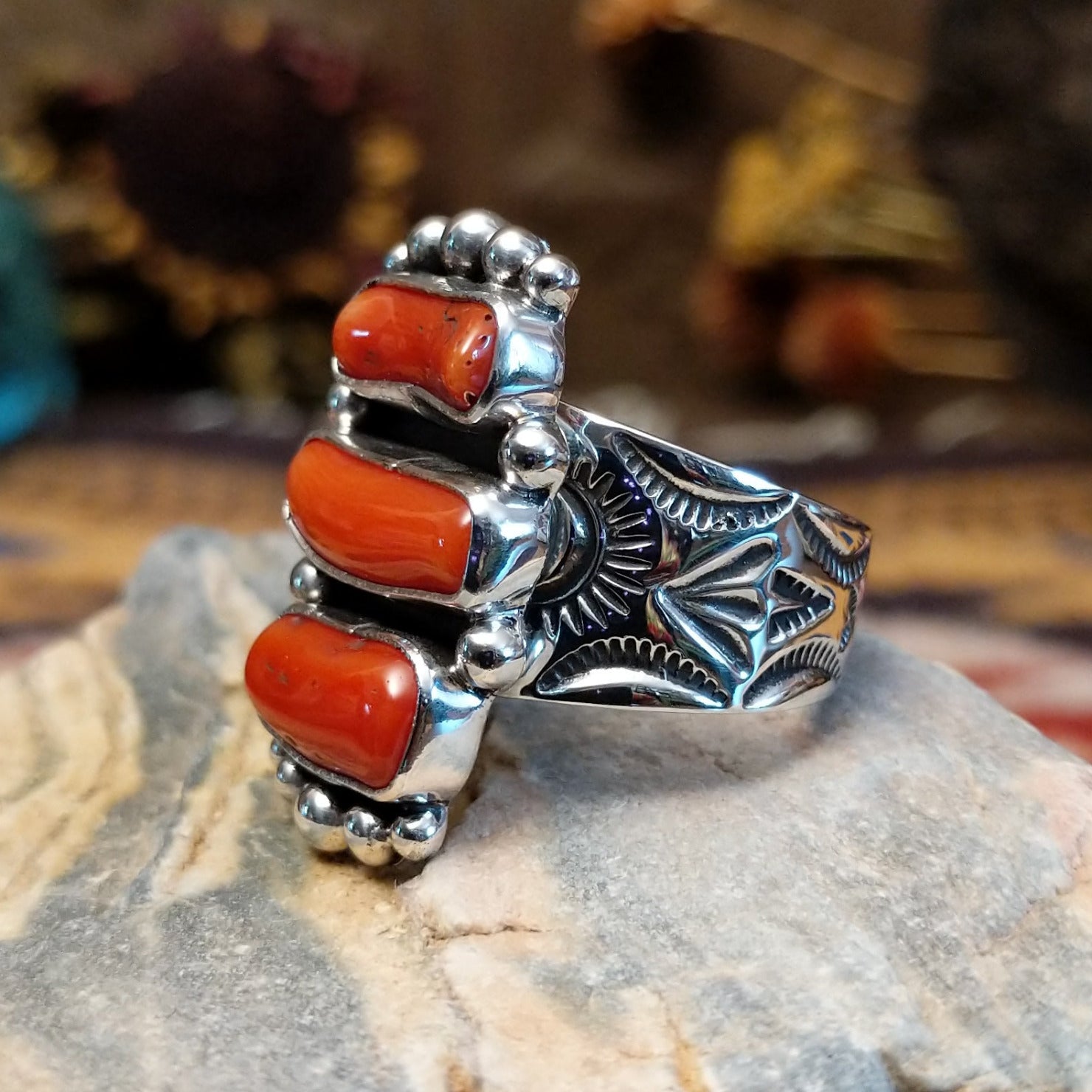 Handcrafted sterling silver ring by Bernyse Chavez featuring multiple stacked coral stones in a bold vertical arrangement with traditional Southwestern Native American detailing.  Side view.