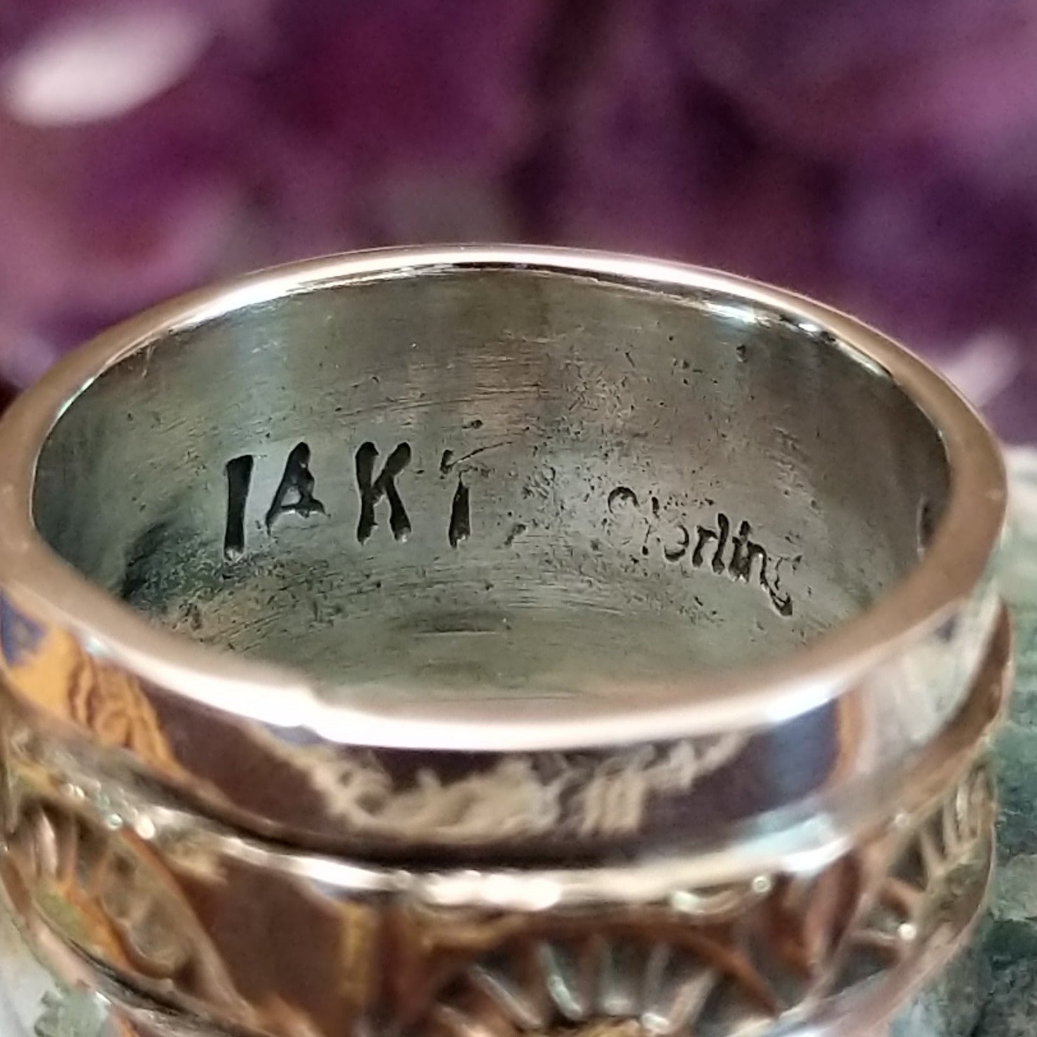 Handcrafted sterling silver and 14K gold band ring by Marc Antia featuring a stamped gold center with polished silver edges in a Southwestern Native American design.  14K gold and Sterling Silver stamp.