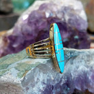 Handcrafted 14K gold navette ring by R.D. featuring vibrant turquoise inlay in a traditional Southwestern Native American design.  Side view.