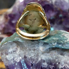 Oval turquoise ring set in a polished 14K yellow gold bezel by Delbert Gordon, featuring natural blue stone with visible matrix patterns and a smooth, minimal gold band design.  Underside view.