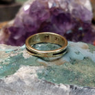Zuni multistone inlay ring in 14K yellow gold by Charlotte Dishta, featuring precise geometric inlay work with multiple natural stones set into a polished gold band.  Underside view.