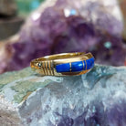 Navajo lapis inlay ring in 14K yellow gold, featuring deep blue lapis lazuli with natural flecks of pyrite set in a smooth polished gold band.  Side view.