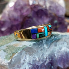 Multistone tiled inlay ring in 14K yellow gold by Steve Francisco, featuring a structured mosaic of individually cut stones set within a polished gold band.  Side view.