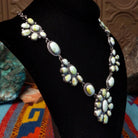 Palomino Variscite Sterling Silver necklace  by Geraldine James, featuring white, cream, pale green, and yellow-green stones arranged in floral-style clusters; side view.
