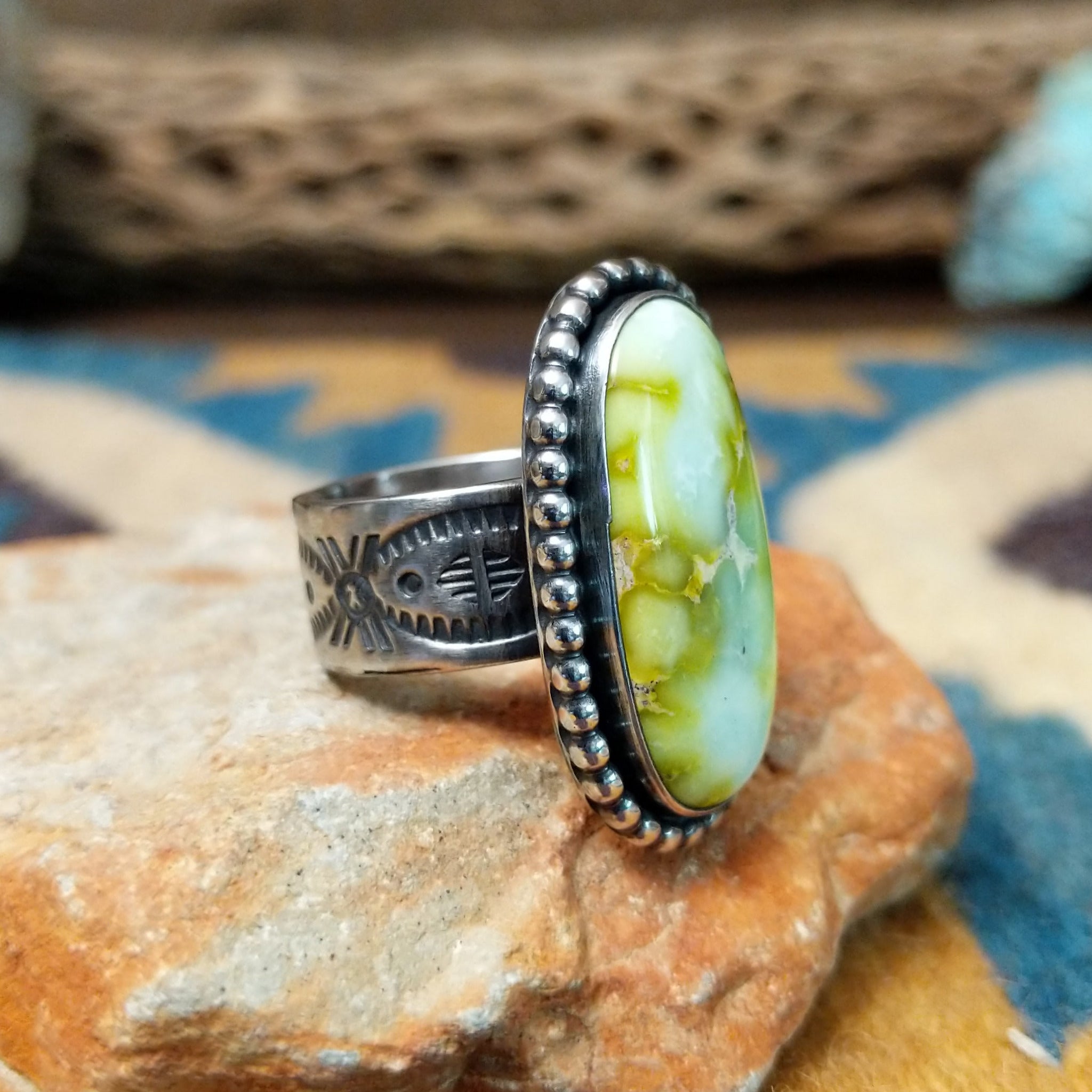 Handcrafted sterling silver Palomino Variscite oval ring by Raymond Coriz, featuring a natural green and white variscite gemstone with a beaded bezel; side view.
