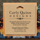 Corkboard backing of a hand-glazed ceramic tile with artist details.