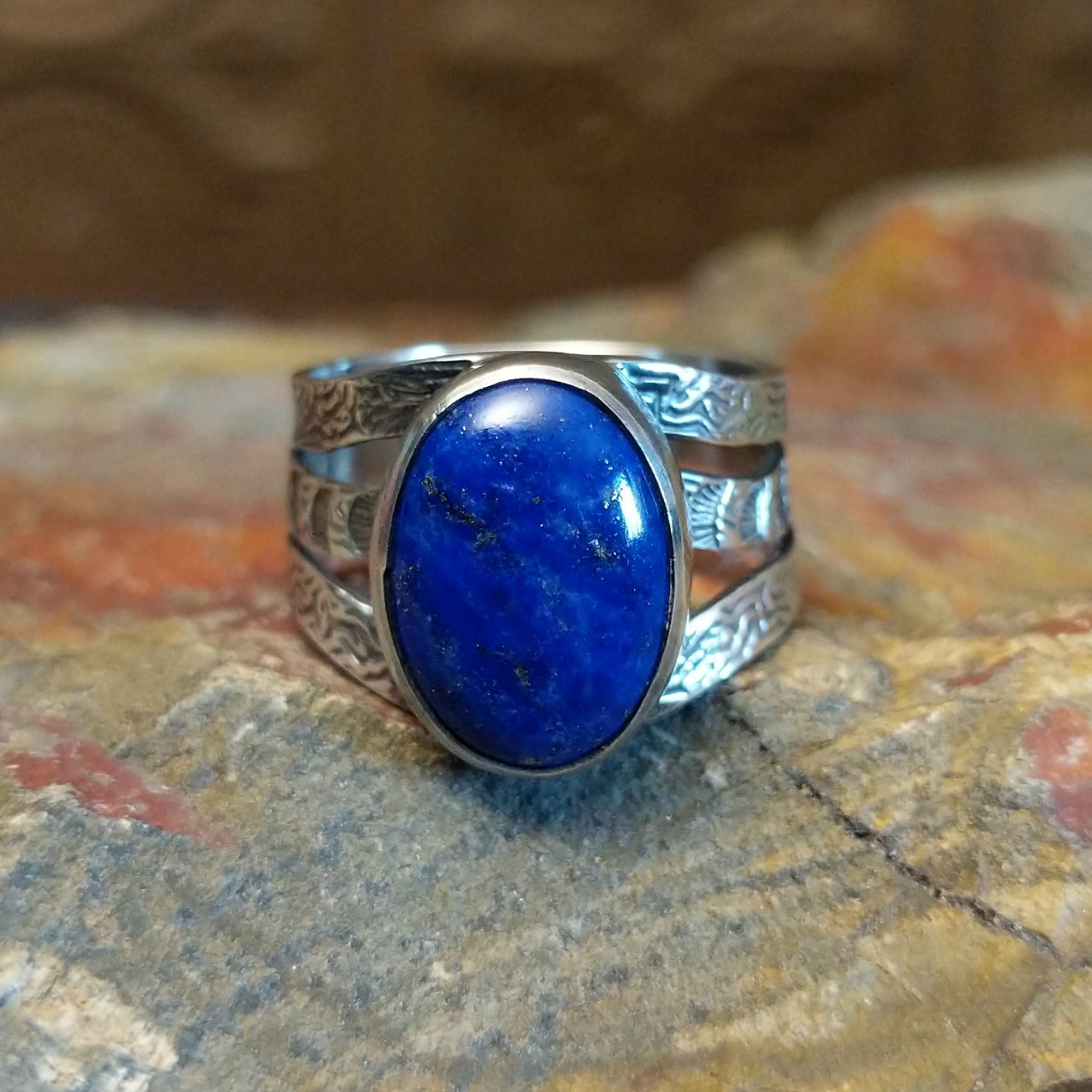 Sterling silver ring with lapis set in the bezel and patterned stamping on the band.