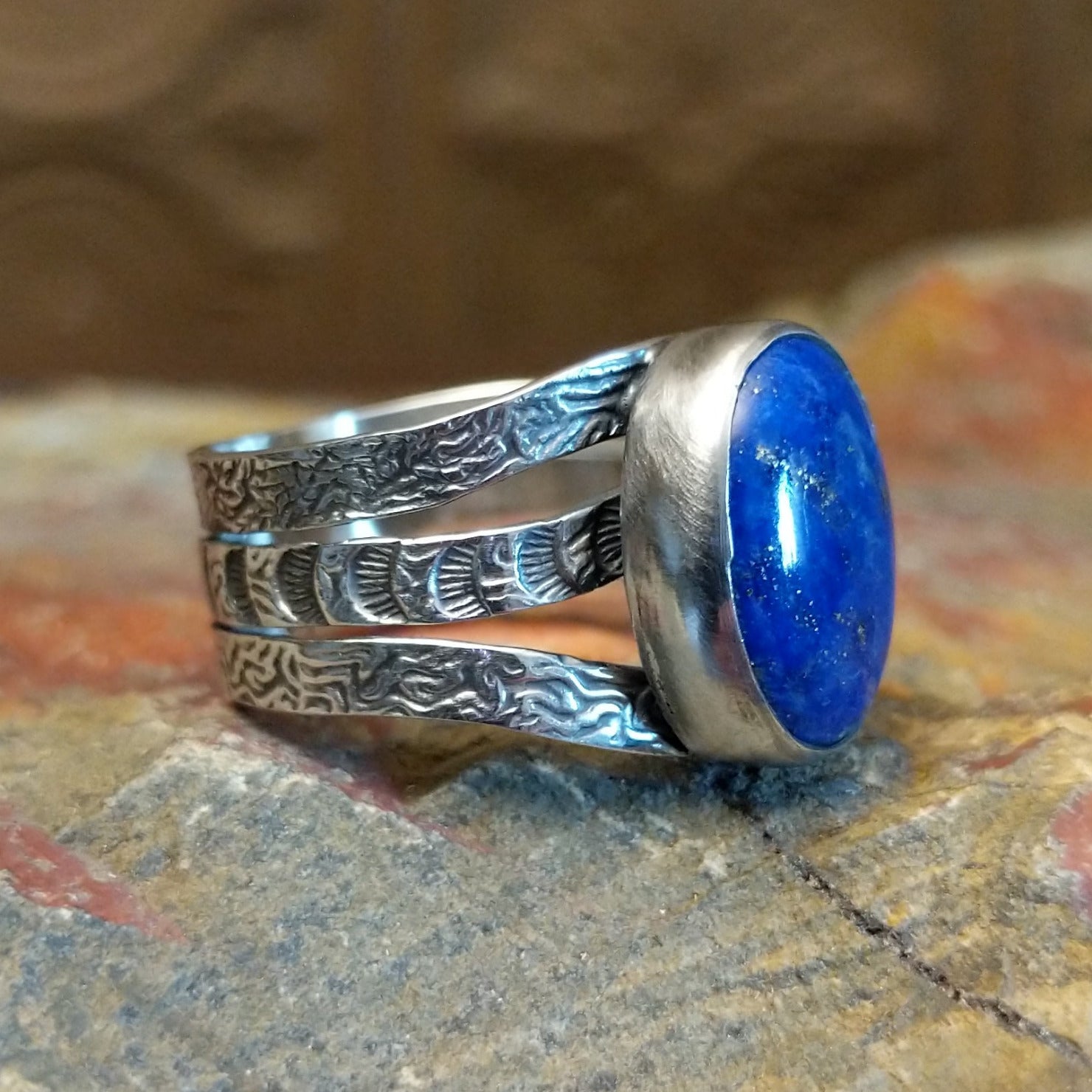 Sterling silver ring with lapis set in the bezel and patterned stamping on the band.