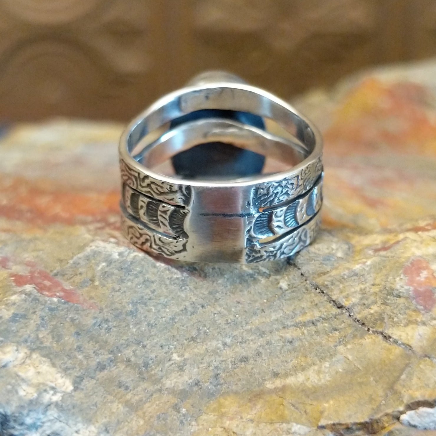 Sterling silver ring with lapis set in the bezel and patterned stamping on the band.