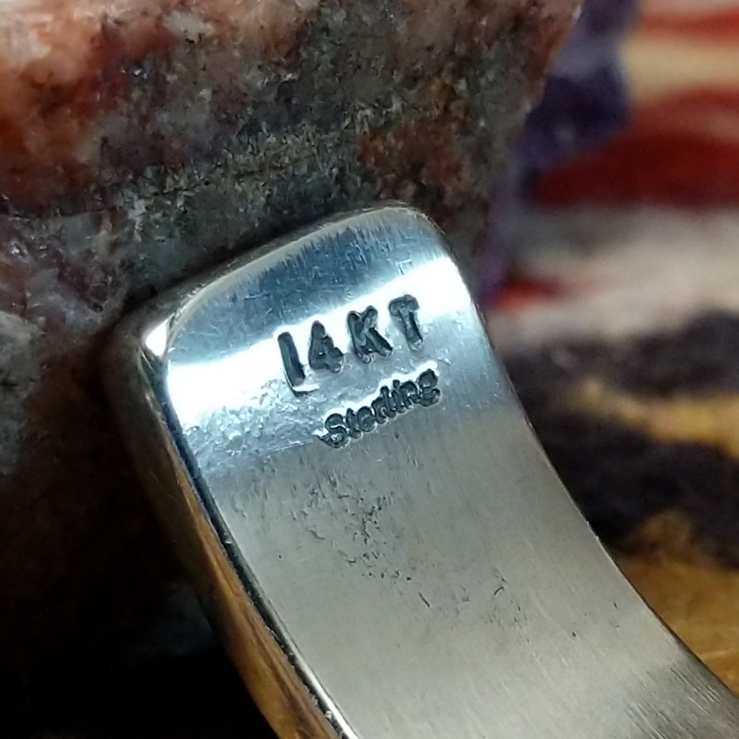 Close up of stamped 14KT and Sterling, indicating 14 karat gold and sterling silver construction.