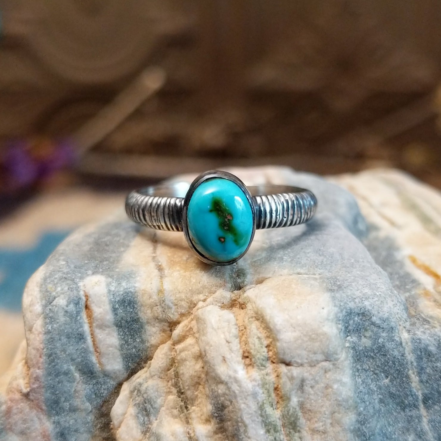 Sterling silver ring with turquoise set in the oval bezel and ribbed band.
