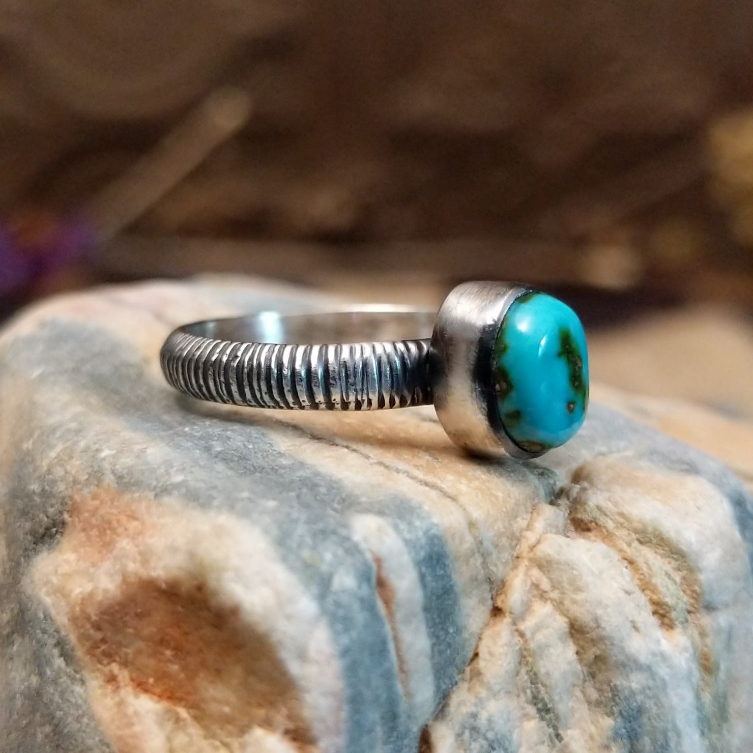 Sterling silver ring with turquoise set in the oval bezel and ribbed band.