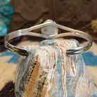 Sterling silver cuff with turquoise set in a round bezel, framed by twisted rope and an incised setting.