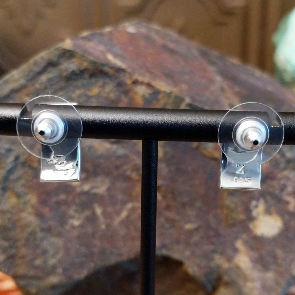 The backs of the earrings feature the artisan's stamped initial.