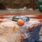 Sterling silver ring with a pink coral set in a raised bezel.