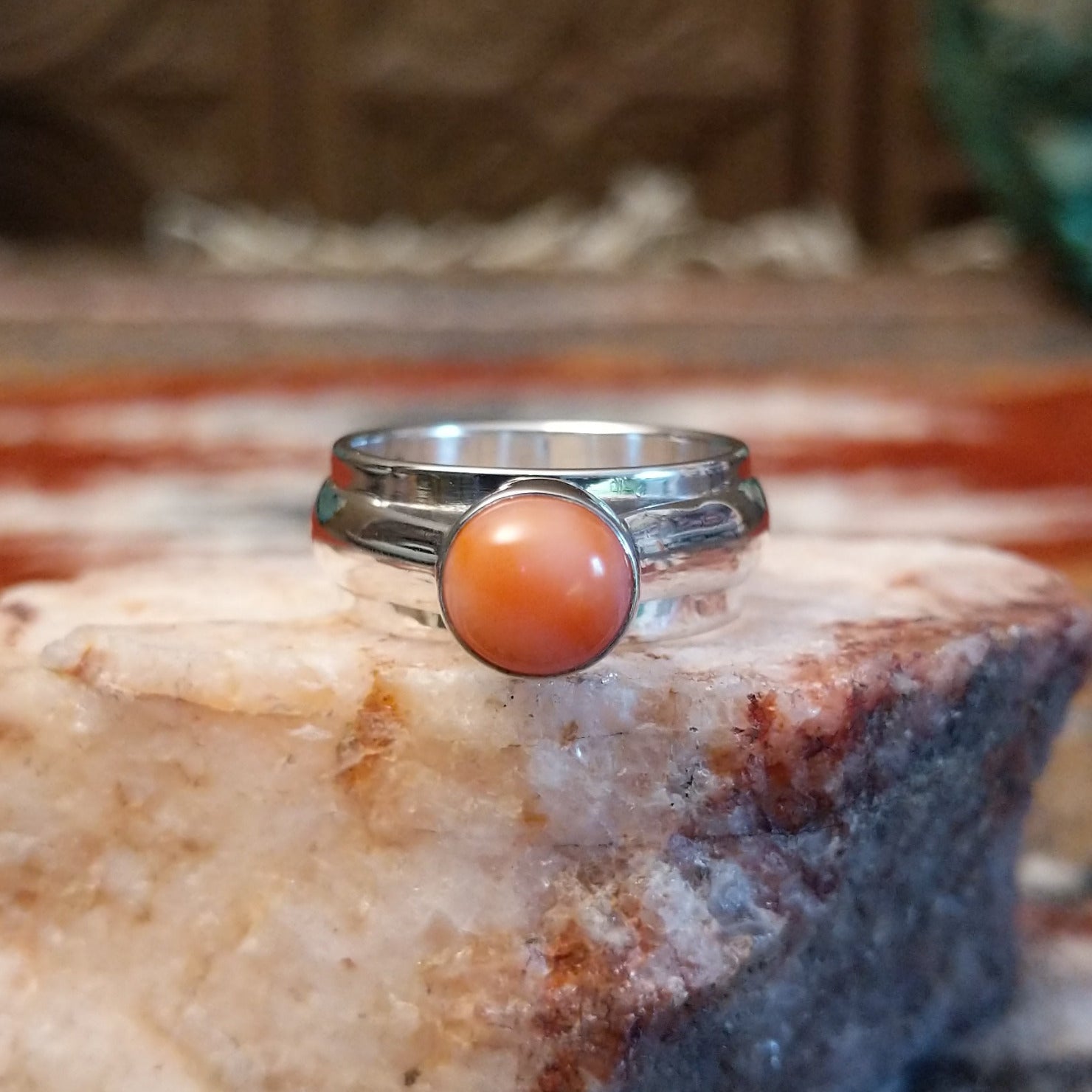 Sterling silver ring with a pink coral set in a raised bezel.