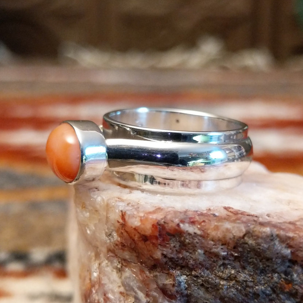 Sterling silver ring with a pink coral set in a raised bezel.