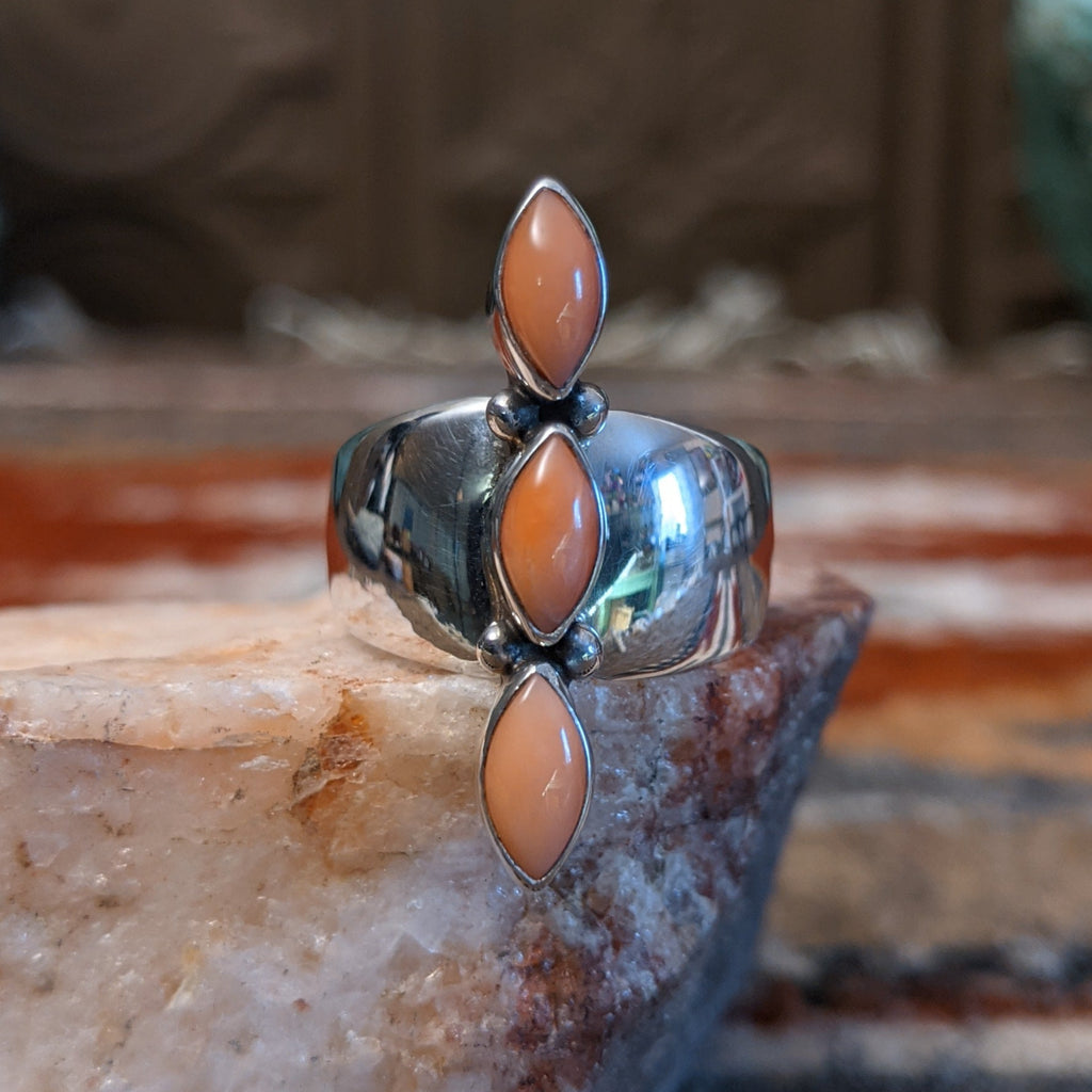 Sterling silver ring with trio bezels and pink coral set within.