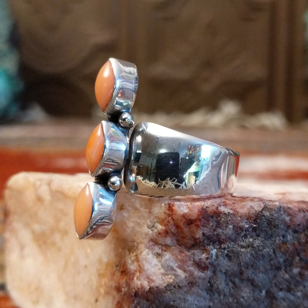 Sterling silver ring with trio bezels and pink coral set within.