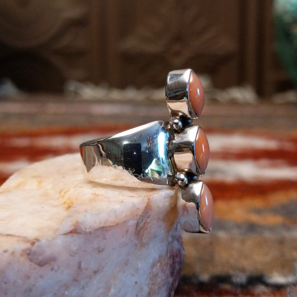 Sterling silver ring with trio bezels and pink coral set within.