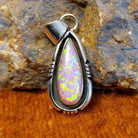 Pink manmade opal set in a shadowbox pendant.