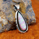 Pink manmade opal set in a shadowbox pendant.