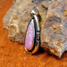 Pink manmade opal set in a shadowbox pendant.