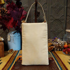 Prickly Pear Club Bag by Bamboo Trading featuring a colorful beaded Southwestern desert landscape with purple mountains, pink and yellow sunset sky, prickly pear cacti with coral-colored blossoms, desert plants, sparkling sequins, and a cream-colored shoulder strap; back side view.