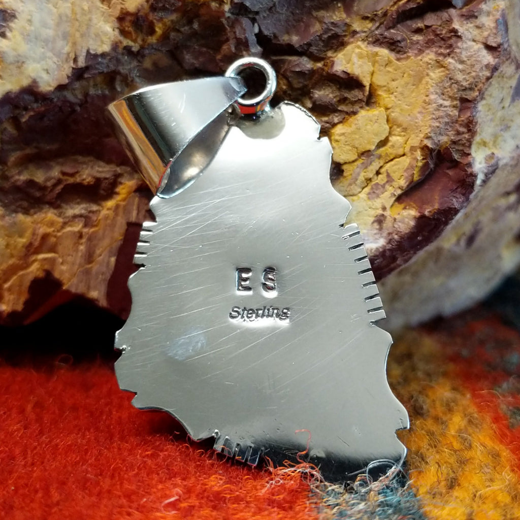 The artisan's initials are stamped on the back of the pendant.