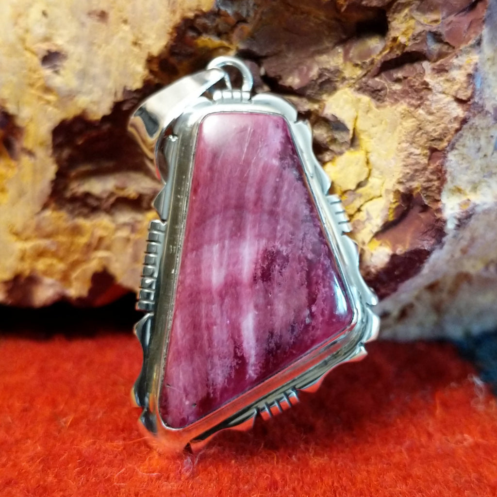 Quadrilateral purple spiny oyster shell set in sterling silver with intricately incised frame.