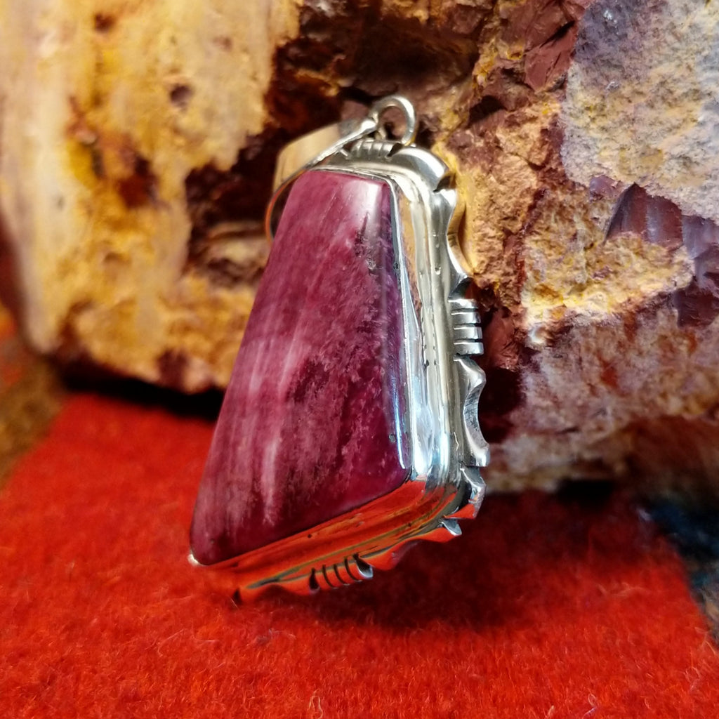 Quadrilateral purple spiny oyster shell set in sterling silver with intricately incised frame.