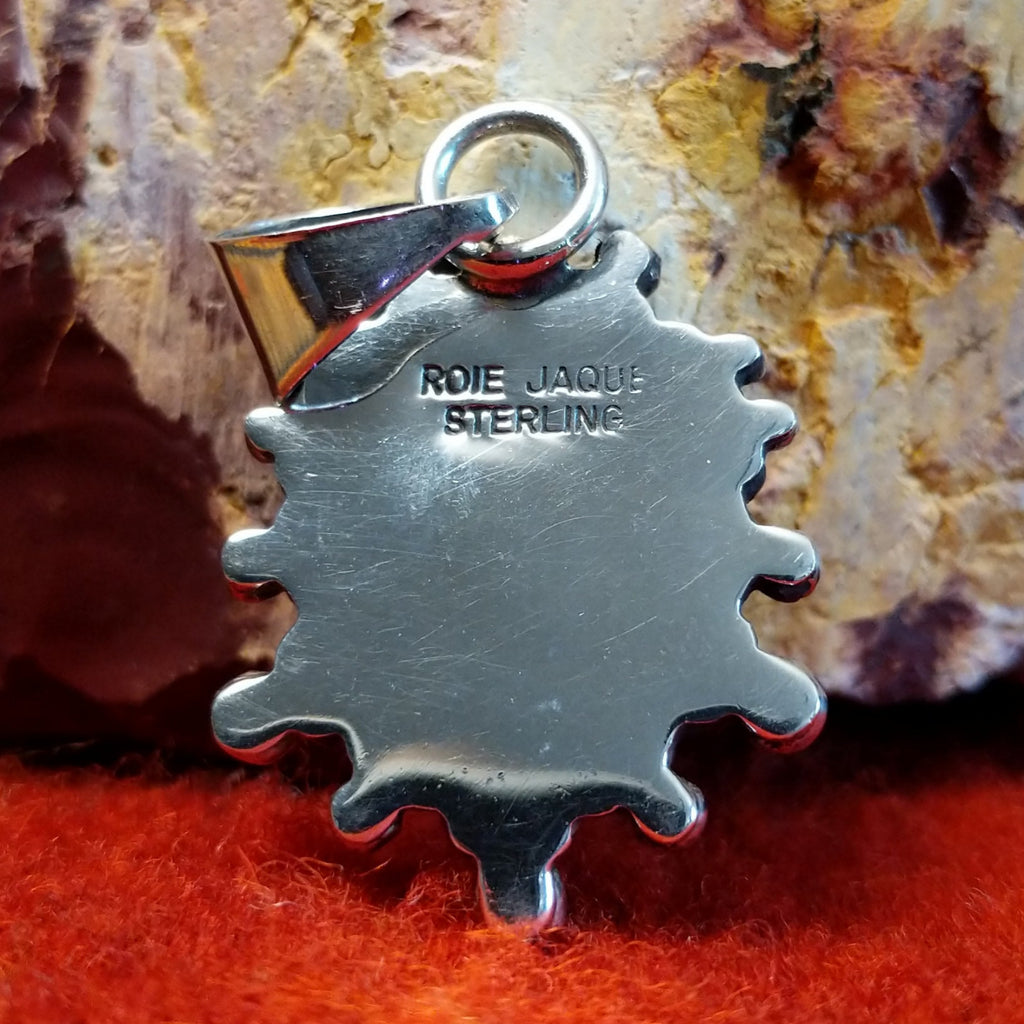 The artisan's signature is stamped on the back side of the pendant.