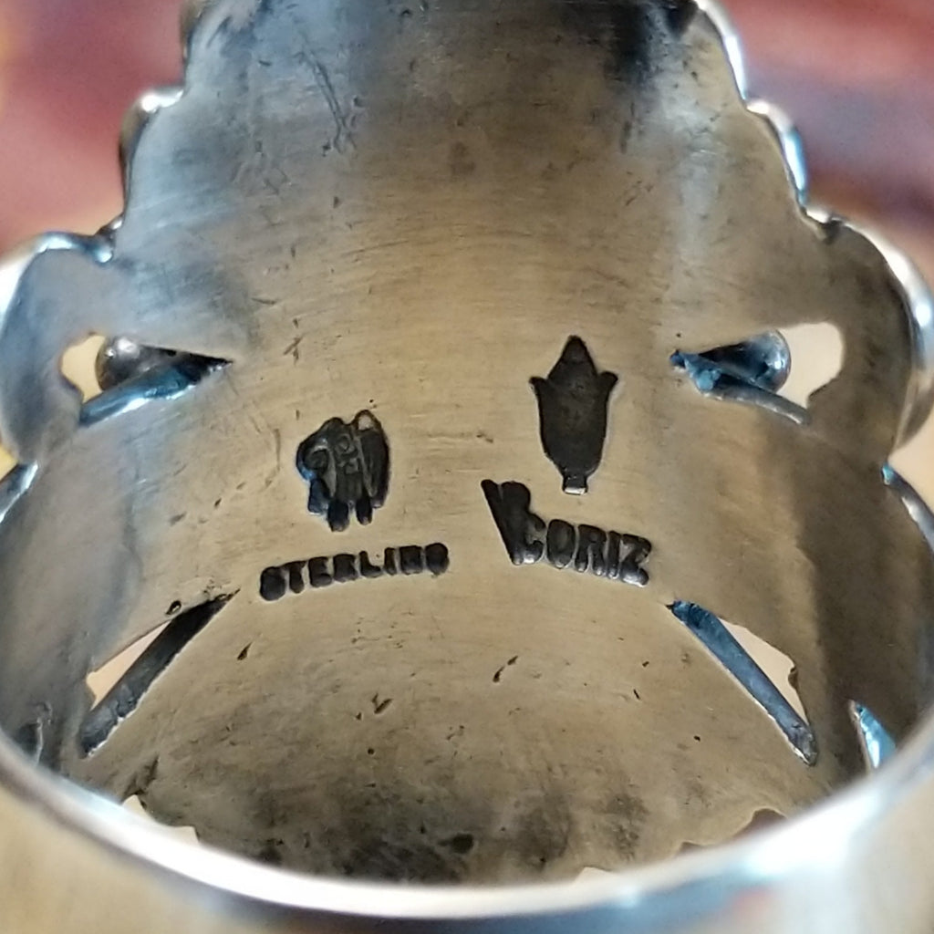 The artisan's signature is stamped on the underside of the setting.