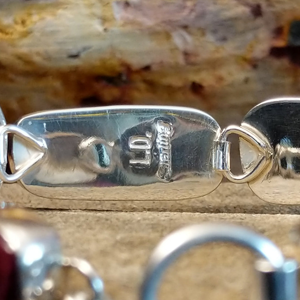 The artist's signature is stamped into the underside of the bracelet.
