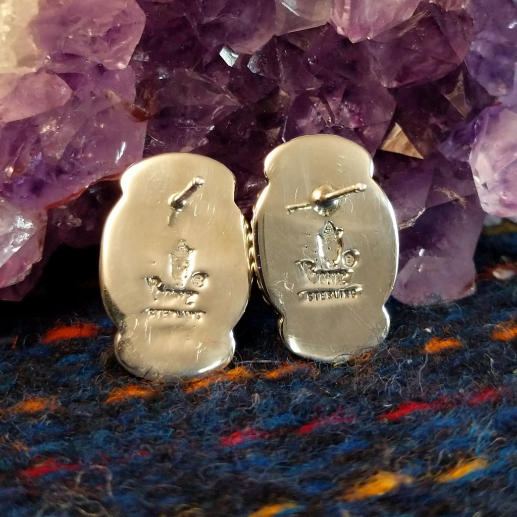 The back view shows the artist's stamp and authentication.