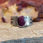 Purple spiny oyster shell set in a smooth bezel on a band with intricate stamp work.