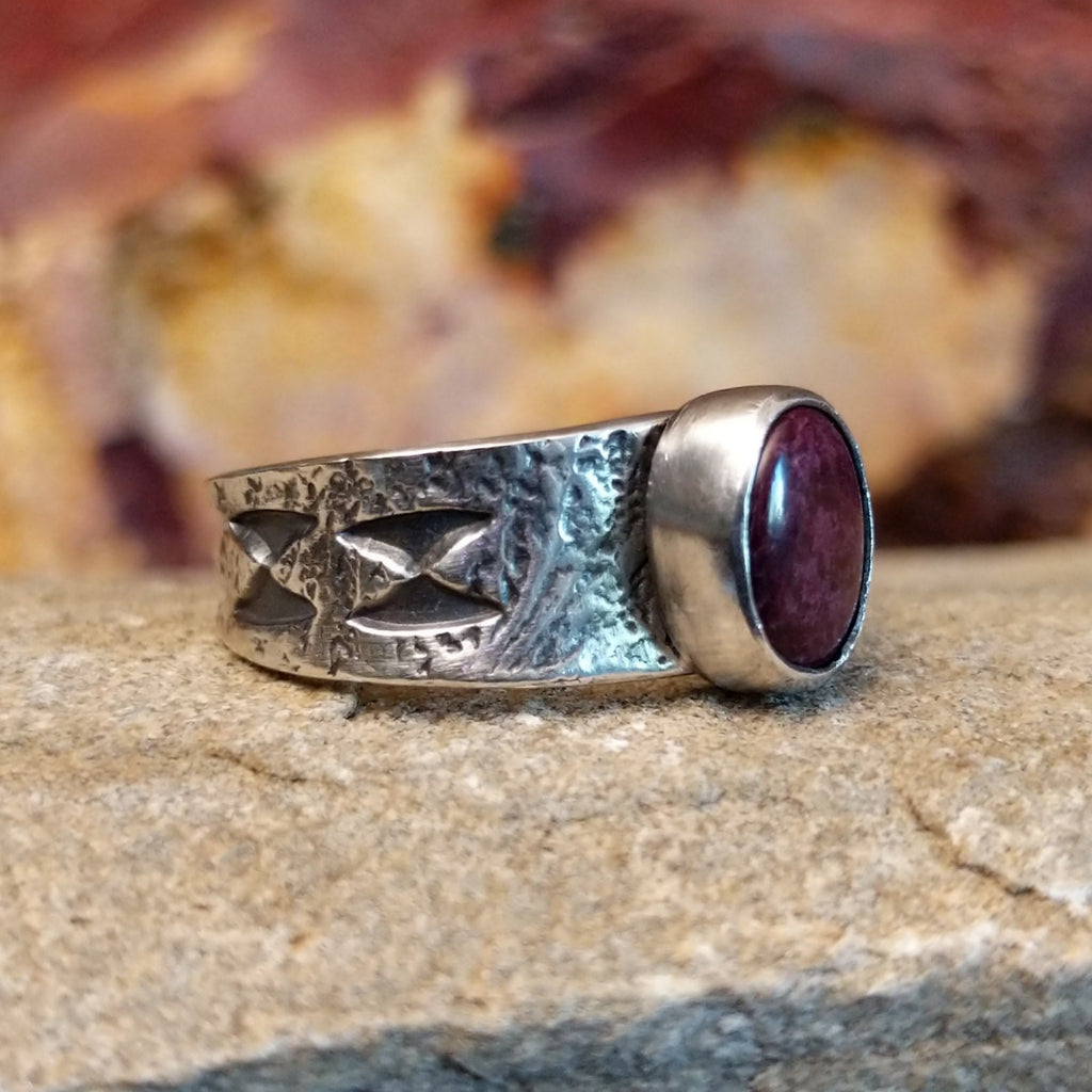 Purple spiny oyster shell set in a smooth bezel on a band with intricate stamp work.