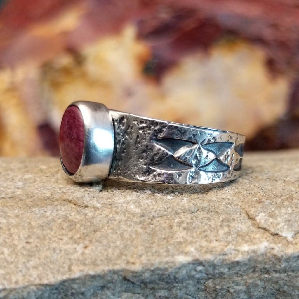 Purple spiny oyster shell set in a smooth bezel on a band with intricate stamp work.