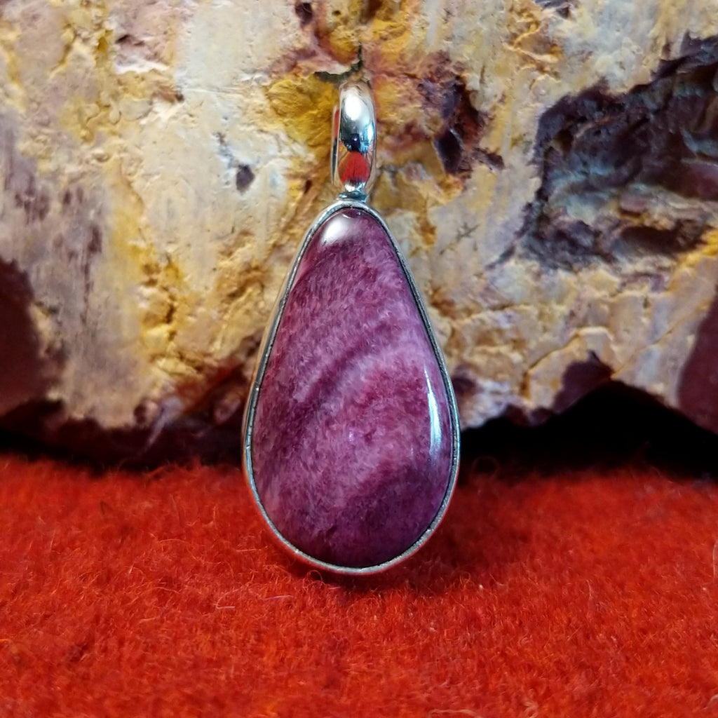 Teardrop shaped sterling silver pendant with purple spiny oyster shell set inside it.