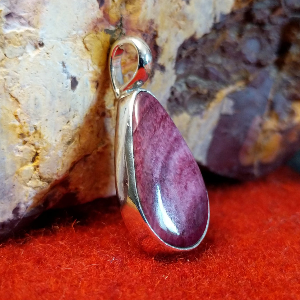 Teardrop shaped sterling silver pendant with purple spiny oyster shell set inside it.