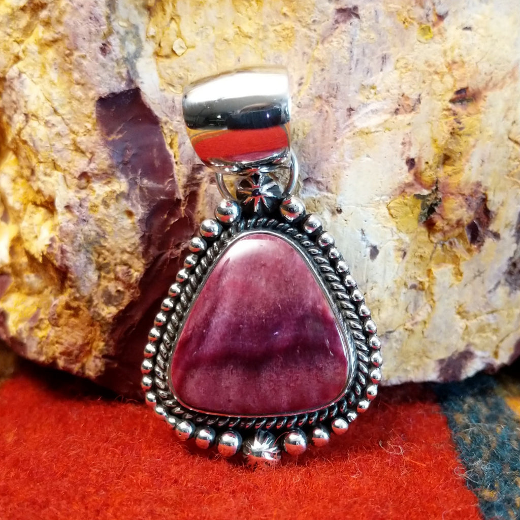 Triangular purple spiny oyster shell set in sterling silver with twisted rope and dot-work details along the frame.