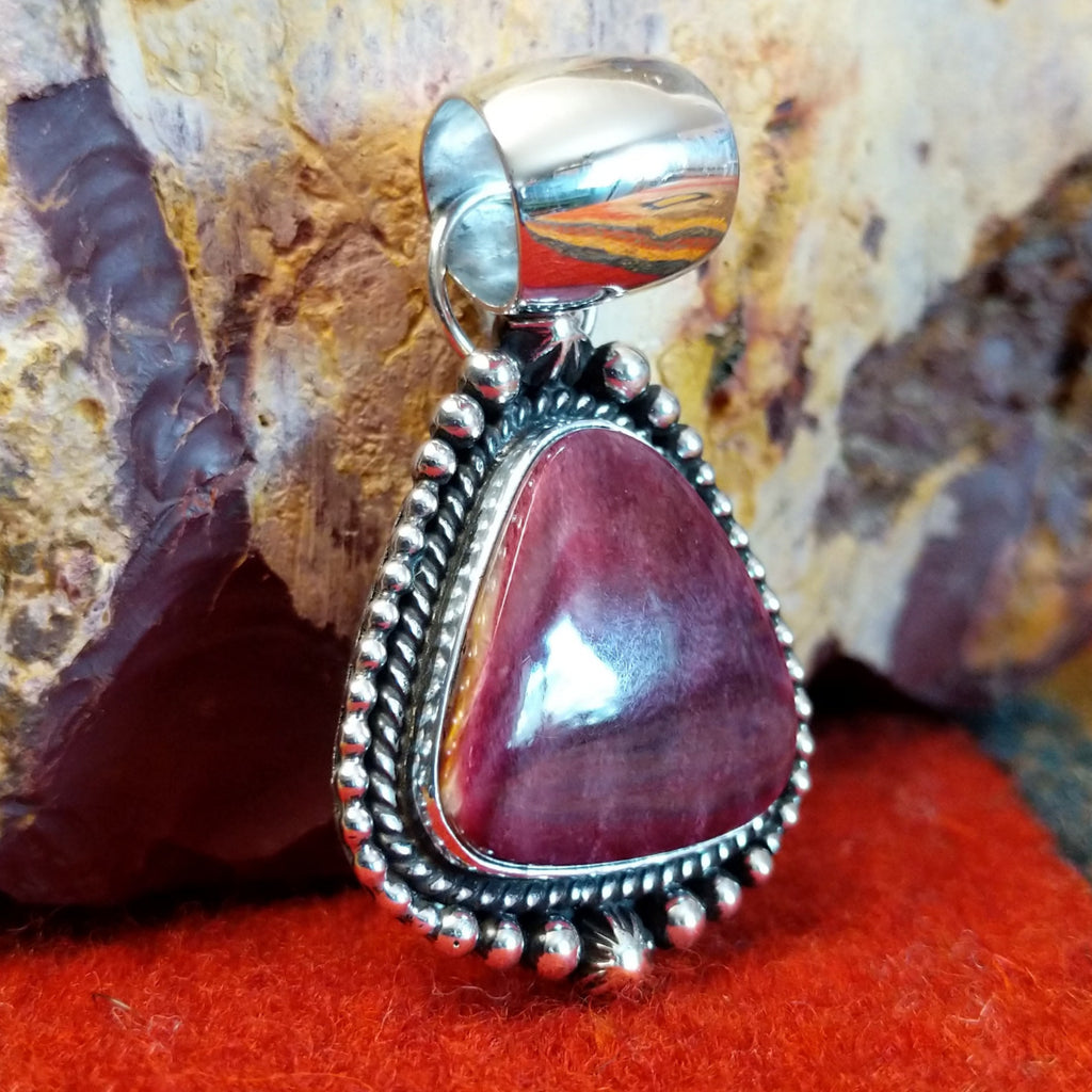 Triangular purple spiny oyster shell set in sterling silver with twisted rope and dot-work details along the frame.