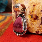 Triangular purple spiny oyster shell set in sterling silver with twisted rope and dot-work details along the frame.