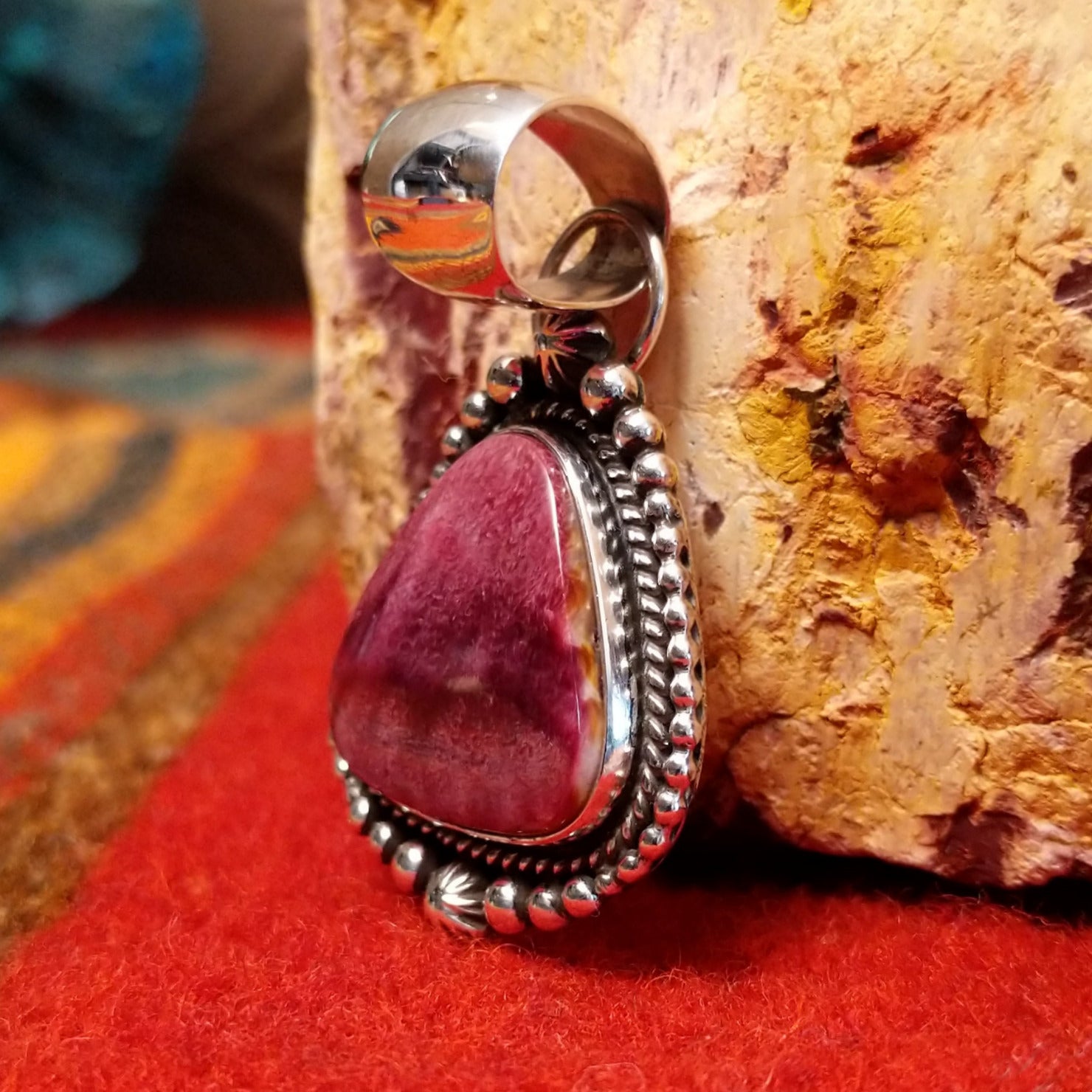 Triangular purple spiny oyster shell set in sterling silver with twisted rope and dot-work details along the frame.