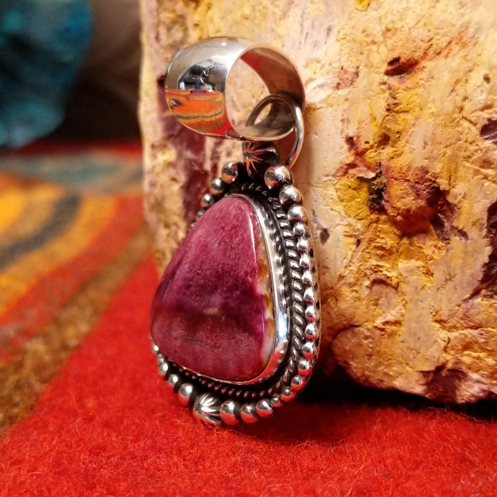 Triangular purple spiny oyster shell set in sterling silver with twisted rope and dot-work details along the frame.