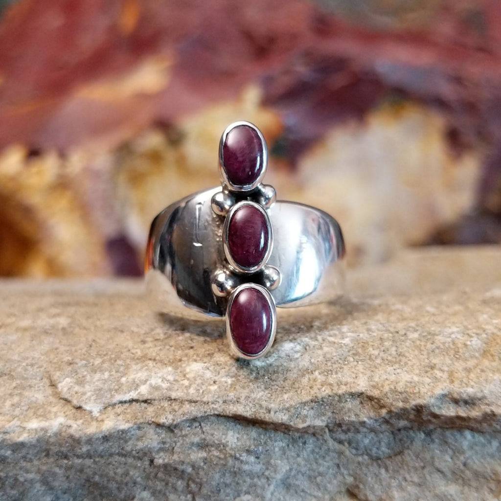 Three small purple spiny oyster shells set on the polished sterling silver band.