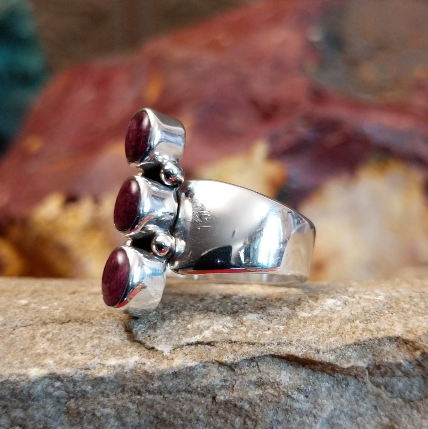 Three small purple spiny oyster shells set on the polished sterling silver band.