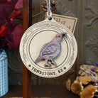 Quail Wood Ornament featuring a layered wooden Gambel's quail with engraved feather details inside a circular frame decorated with Southwestern geometric patterns, "Tombstone, AZ" lettering, and a natural twine hanging loop.