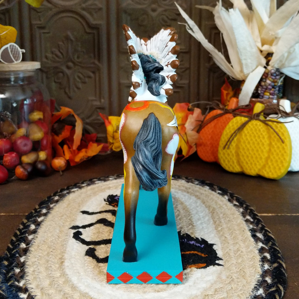 Resin pony painted brown and white with Native American motifs and a traditional headdress.